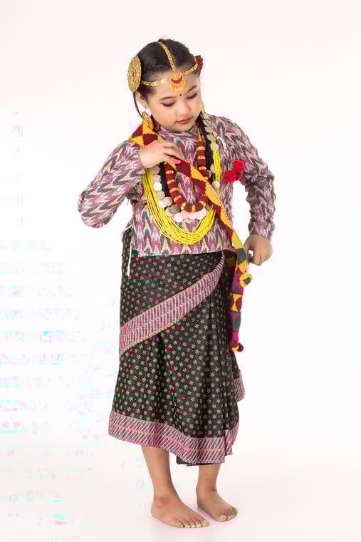 A cute traditional little girl posing while wearing cultural attire