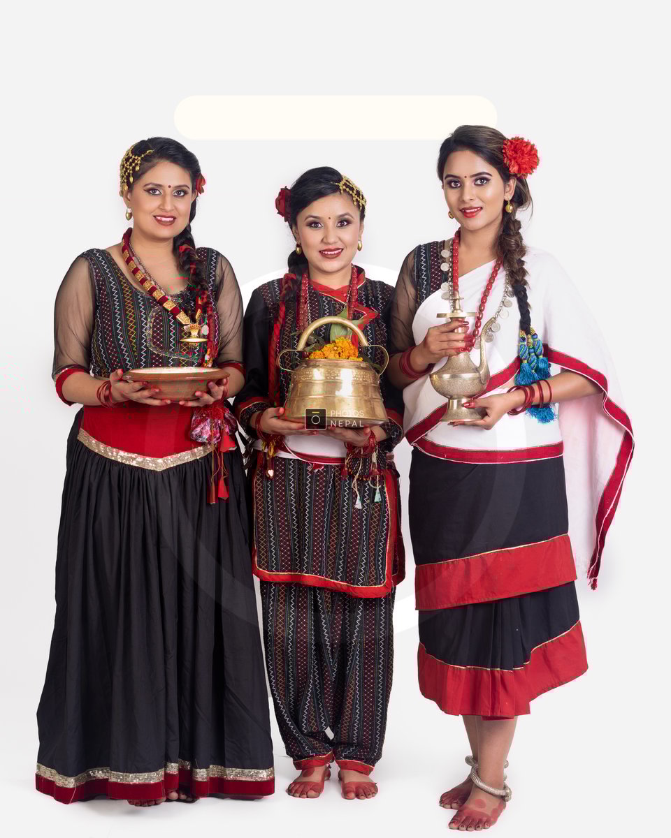 Young Newari girls in traditional Newari garb are carrying a vessel ...
