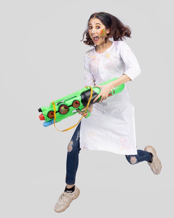 Celebrating Holi with Joy Nepali Girl Jumping with a Water Gun