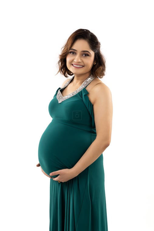 Pregnant Nepali Woman in Green Mermaid Gown Touching Belly Studio